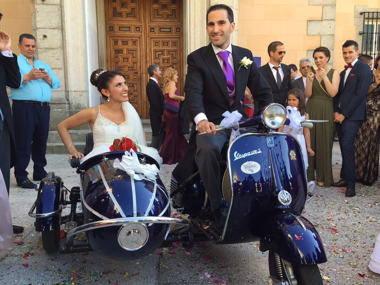 Novios junto a una Vespa con sidecar a la salida de la ceremonia