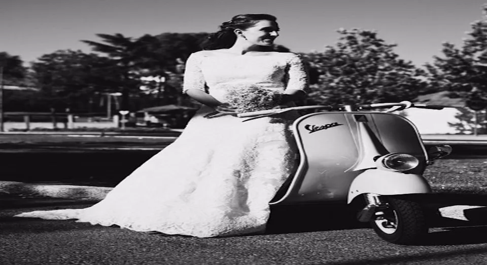 Retrato en blanco y negro de una novia junto a una Vespa clásica