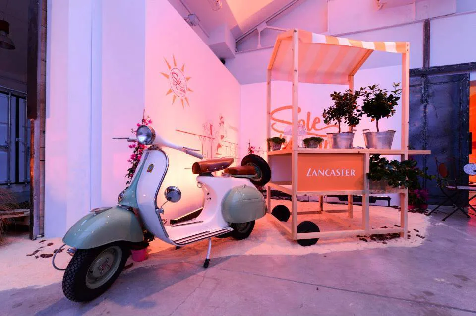Vespa clara integrada en un montaje de interior con flores y mobiliario