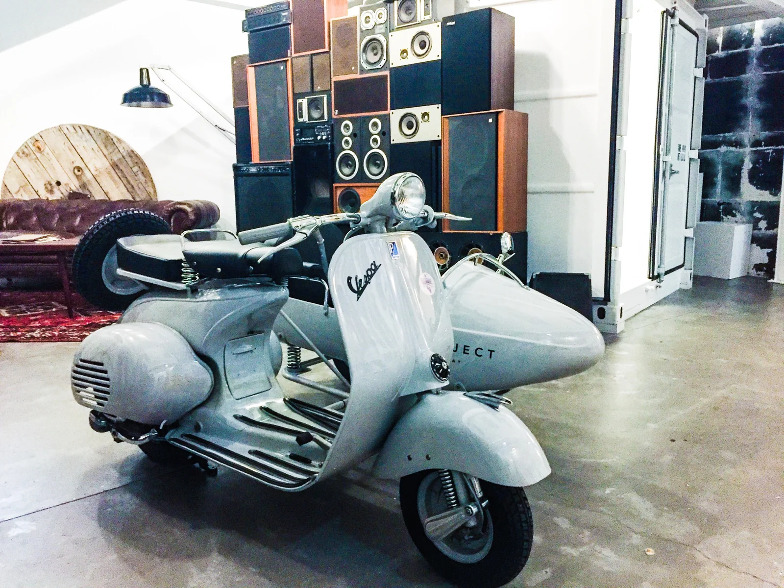Vespa clásica con sidecar expuesta en un espacio interior