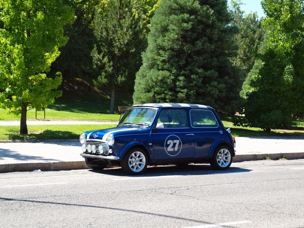 Coche clásico azul en una calle arbolada